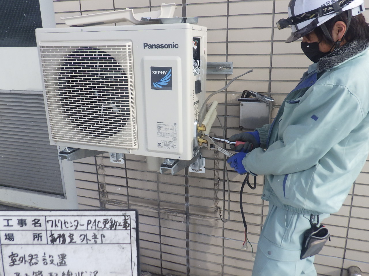 エアコン室外機を取り付ける狩野設備工業の作業員。空調・冷暖房設備工事の様子